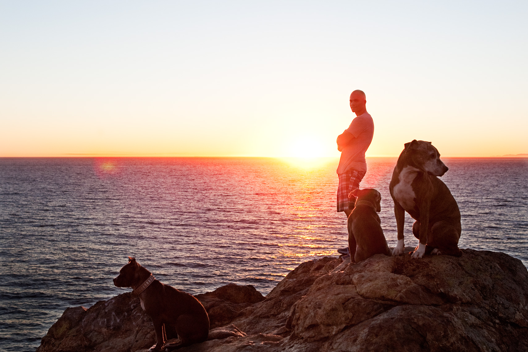 Los Angeles Dog Photography, Michael Brian, Dog Trainer Tyson Kilmer stands against a sunset with dogs